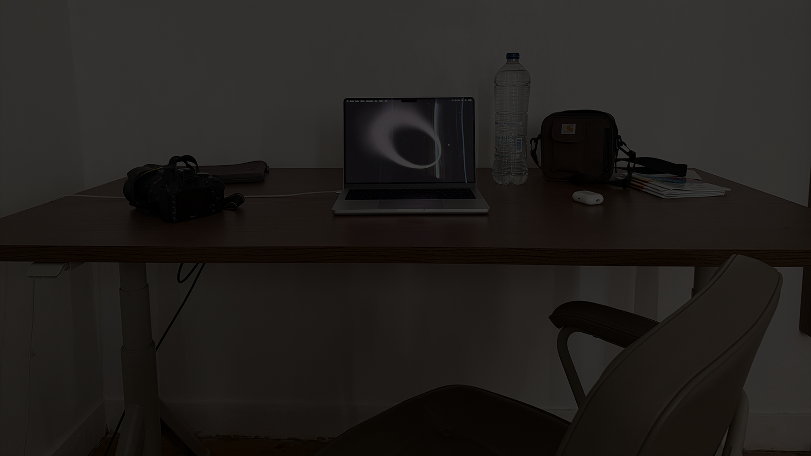 Photo du bureau de Keelan ; un ordinateur est allumé et ouvert avec quelques objets posés sur la table de travail.