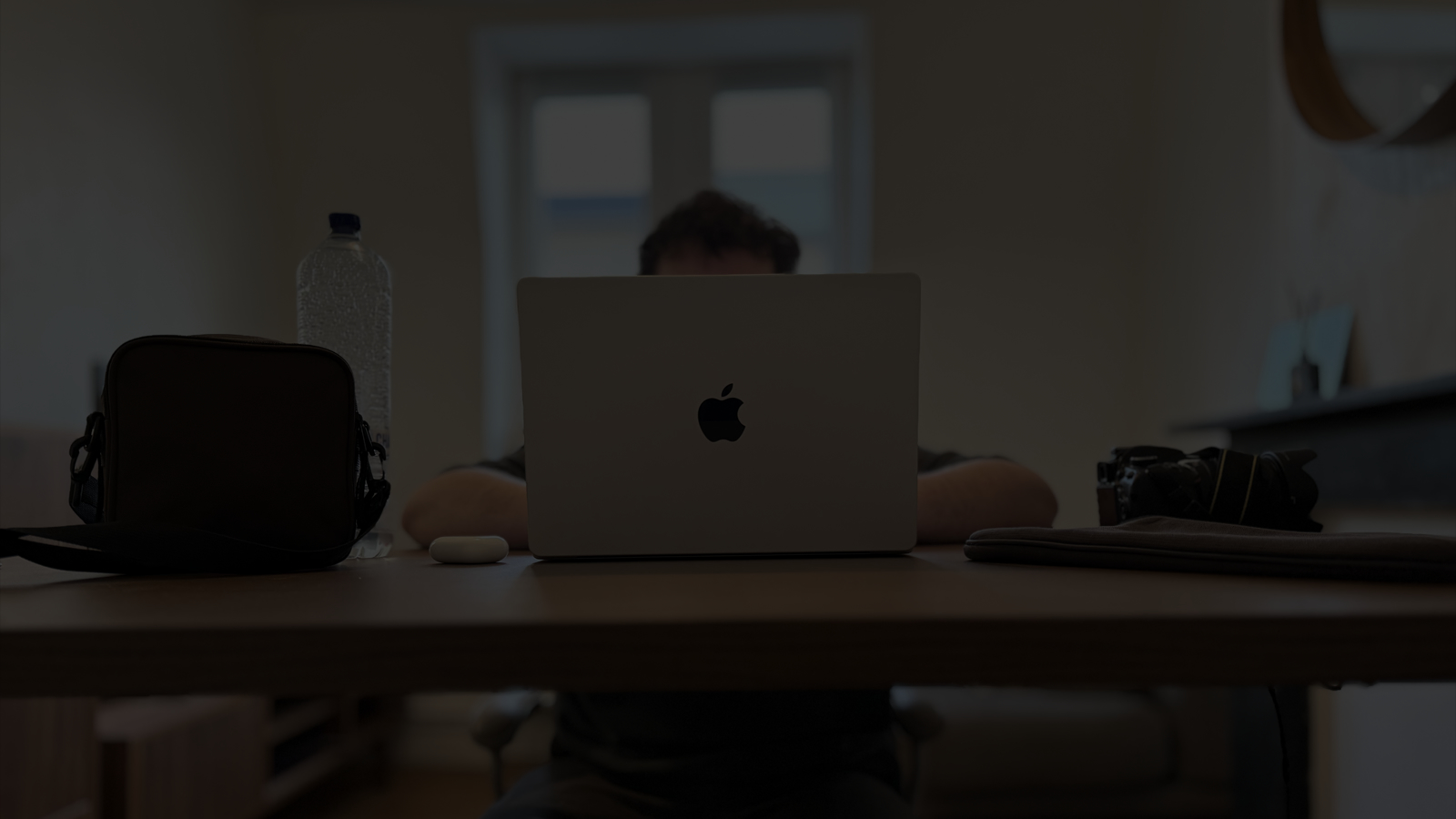 Photo de Keelan assis à son bureau caché en plein travail derrière son ordinateur.